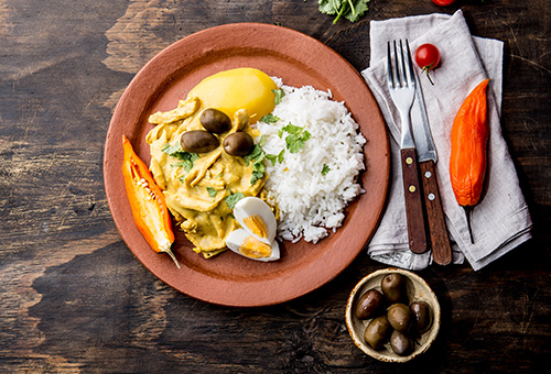 Peruanisches Gericht Aji de Gallina auf einem Teller angerichtet.