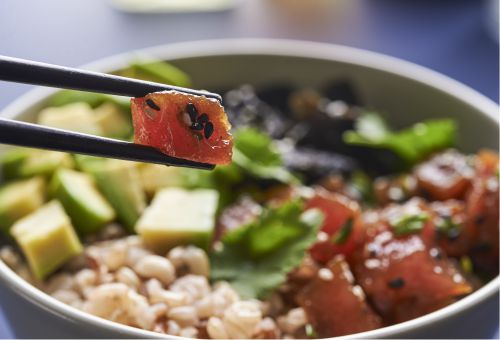 Schüssel mit Avocado-Stückchen, Reis und rohen Thunfisch-Stückchen