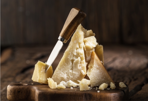 Parmesankäse mit Messer auf Käsebrett Parmesankäse mit Messer auf Käsebrett