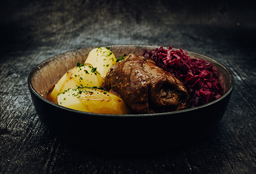 Rinderrouladen mit Kartoffeln und Rotkohl auf einem Teller