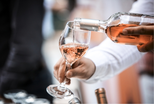 Roséwein wird vom Kellner eingegossen Roséwein wird vom Kellner eingegossen