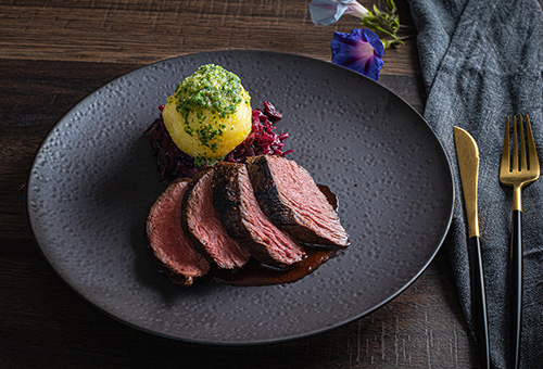 Sauerbraten mit Klößen und Rotkohl auf Teller