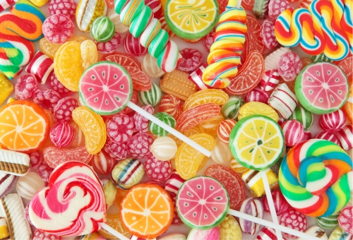 Verschiedene bunte Süßigkeiten auf einem Tisch Bunte Bonbons und Lutscher gemischt auf einem Tisch