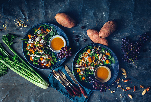 Süßkartoffel-Quinoa-Salat auf Tellern angerichtet.