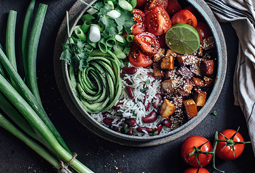 Tofu-Bohnen-Salat mit Gemüse angerichtet auf einem Teller.