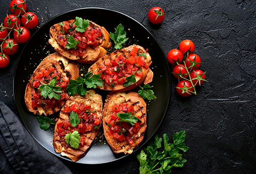 Vegane Bruschetta auf schwarzem Teller angerichtet