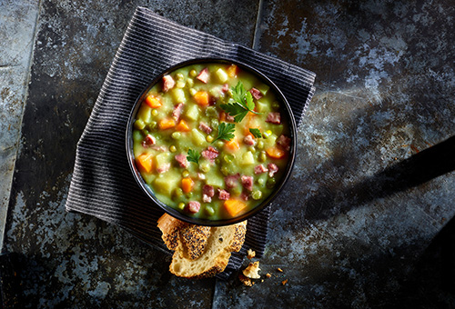 Erbsensuppe mit Kassler und Würstchen in Suppenschüssel