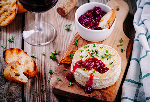 Gebackener Camembert mit Preiselbeeren Gebackener Camembert mit Preiselbeeren auf einem Holzbrett angerichtet und mit Thymian dekoriert