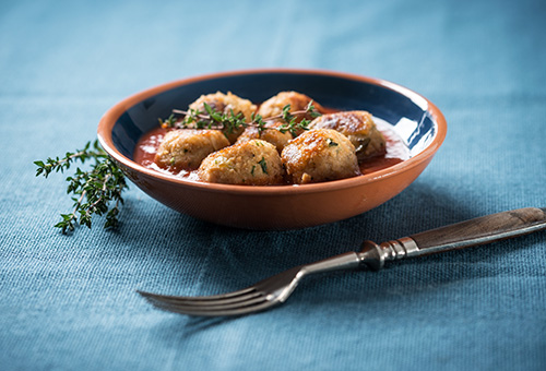 Gefüllte Hackbällchen in Glühweinsoße in einer braunen Schüssel angerichtet