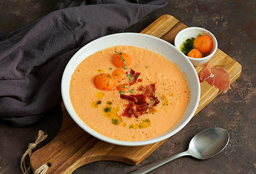 Kalte Melonensuppe mit Schinken angerichtet im Suppenteller