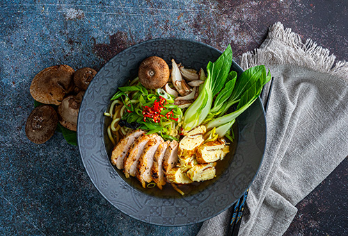 Ramen Suppe mit Perlhuhnbrust angerichtet in Suppenschüssel