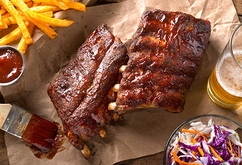 Spareribs auf einem Backpapier mit Pommes