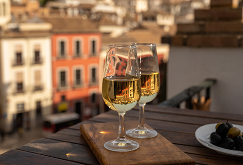 Zwei Gläser Sherry Zwei Gläser mit Sherry auf einem Tisch auf einem Balkon mit Ausblick über eine Stadt
