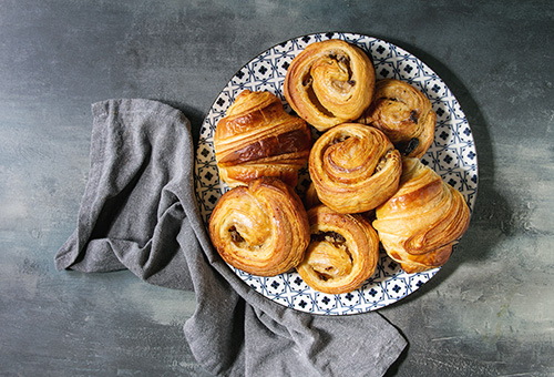 Croissants und Escargots aus Blätterteig auf einem Teller