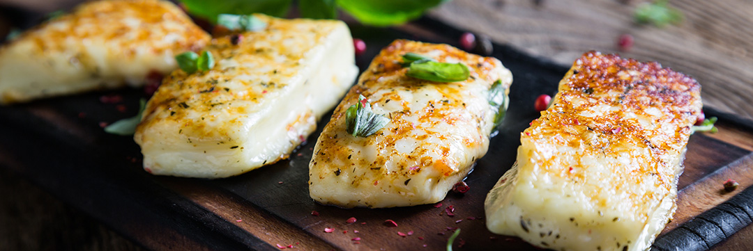 Gebratener Halloumi Gebratener Halloumi auf einem Holzbrett angerichtet