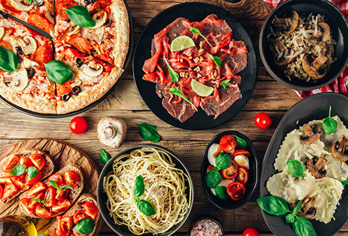 Pizza, Pasta, Bruschetta und Antipasti auf einem Tisch schön angerichtet