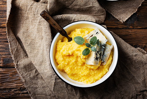 Gekochte Polenta in einer Schale angerichtet mit Gorgonzola