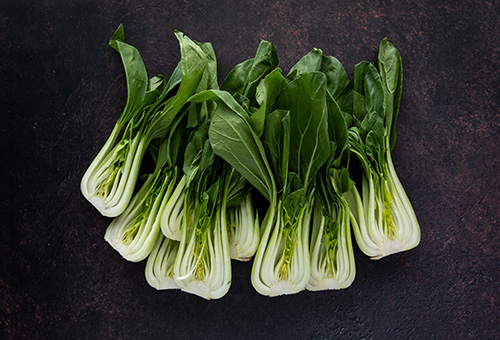 Pak Choi Mehrere Pak Choi liegen nebeneinander auf einer dunklen Fläche