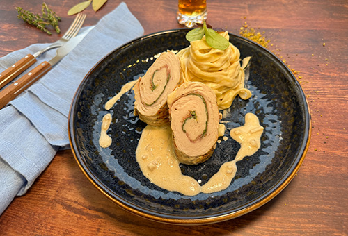 Involtini von der Putenbrust, auf einem blauen Teller angerichtet mit Tagliatelle und flambierter Whisky-Sauce