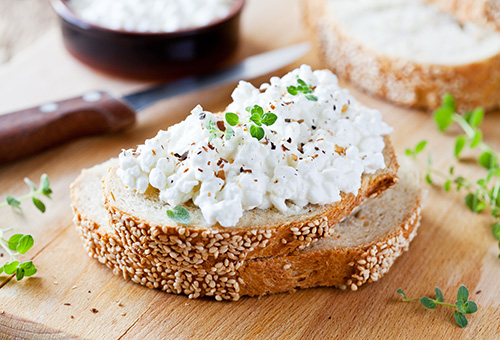 Hüttenkäse auf Brotscheibe mit Schnittlauch dekoriert