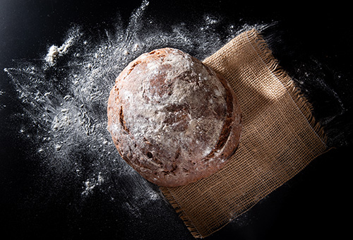 Rundes Sauerteigbrot mit Mehl bestäubt von oben fotografiert