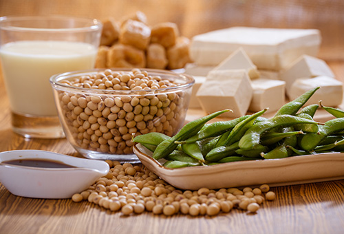 Tisch mit Edamame, Sojabohnen, Naturtofu, Sojasoße und Sojamilch