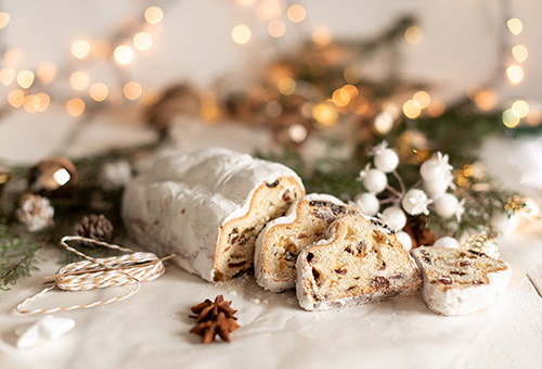 Weihnachtsstollen Angeschnittener Weihnachtsstollen auf einem weihnachtlich dekorierten Tisch