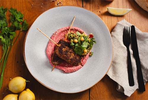 Rezept: Reh Köfte auf Tabouleh und Rote Bete Hummus Zwei Reh Köfte Spieße liegen auf Tabouleh und Rote Bete Hummus