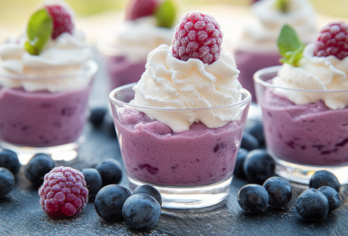 Süße Mousse-Variationen Drei Schalten mit Himbeermousse, mit Sahnetopping und einer Himbeere