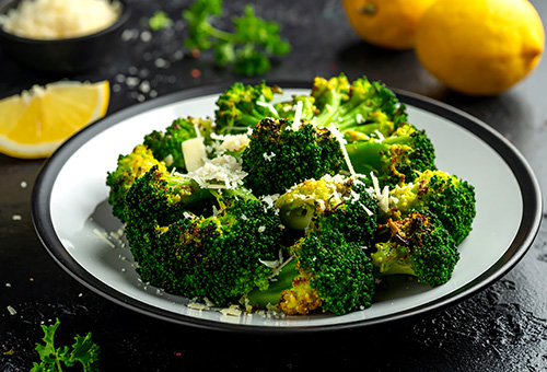 Gekochter Brokkoli auf Teller mit Zitronen dekoriert
