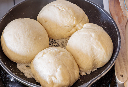 Unterschiede von Dampfnudeln Dampfnudeln in einer Pfanne