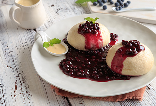 Zusammensetzung von Dampfnudeln Dampfnudeln mit Kompott auf Teller