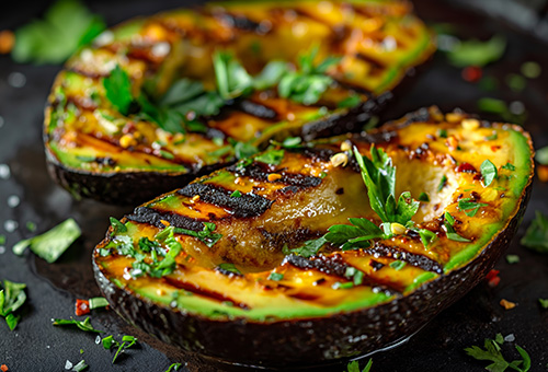 Zwei gegrillte Avocadohälften mit Petersilie und Chiliflocken garniert Zwei gegrillte Avocadohälften mit Petersilie und Chiliflocken garniert