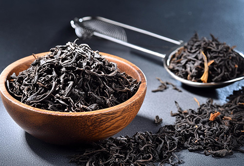 Schwarztee kommt ursprünglich aus China Schale voll getrockneter Blätter für einen Schwarztee